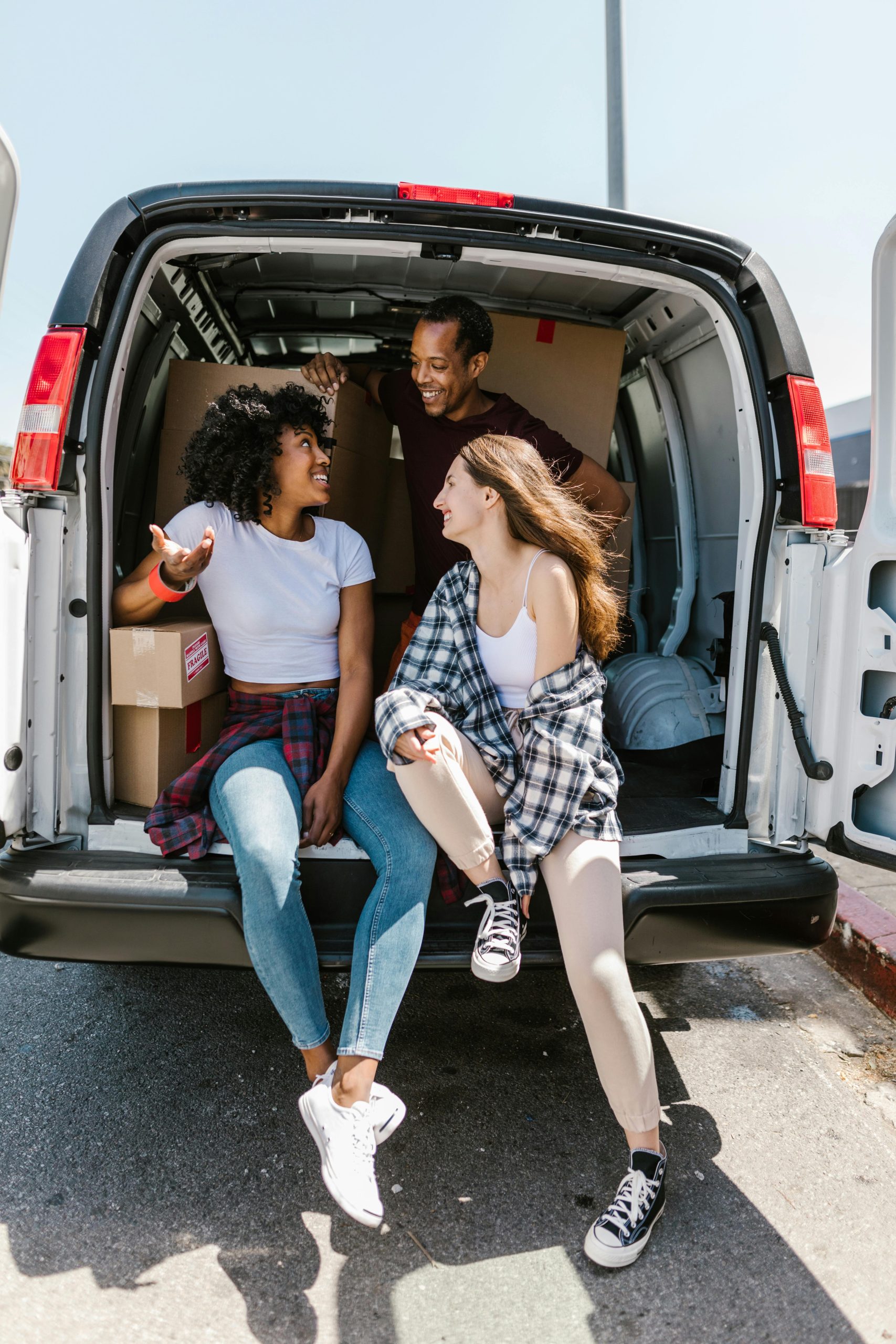 three people discussing how they're going to fit everything in their van size