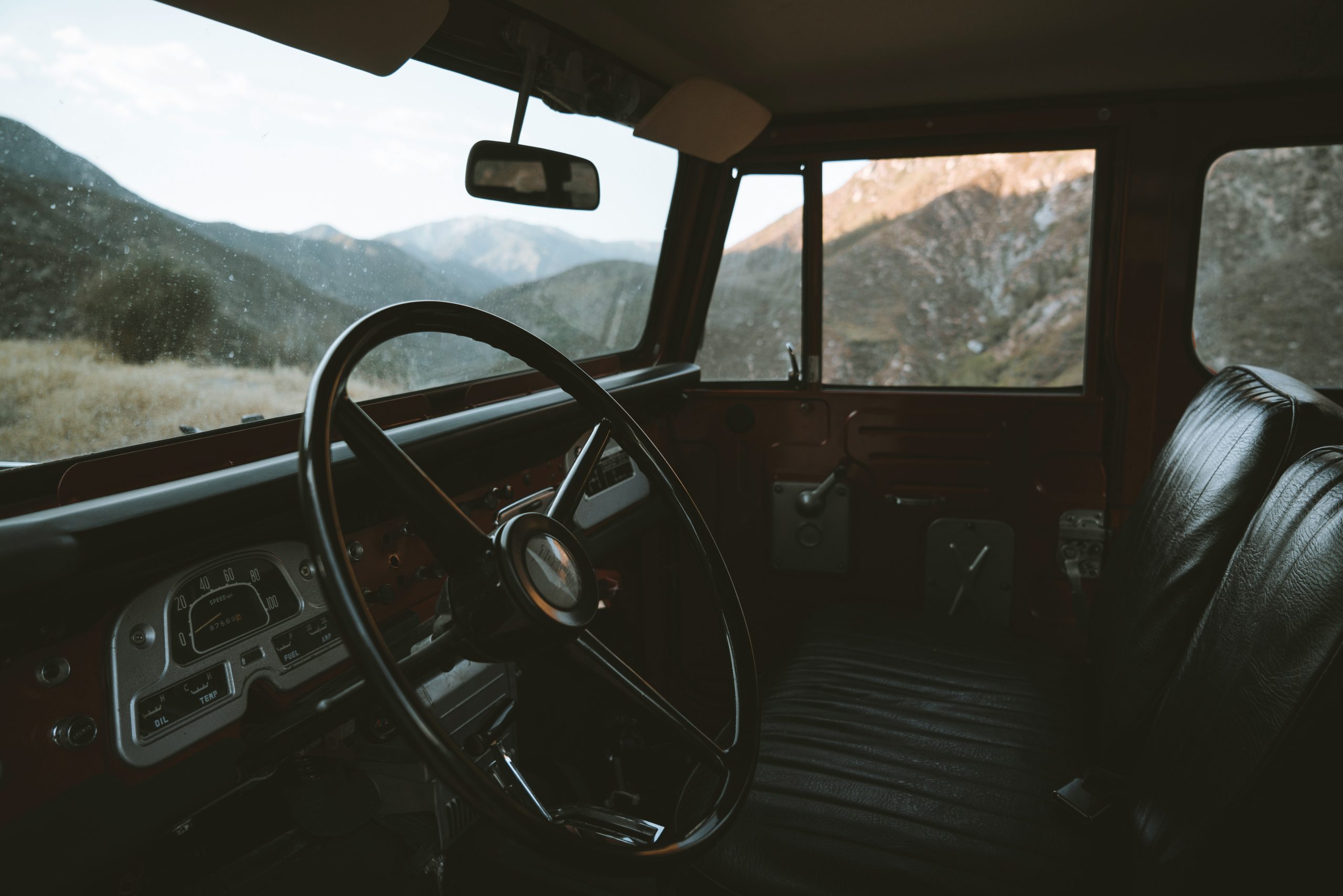 interior view of a van cabin parked on a mountain overlooking the view.